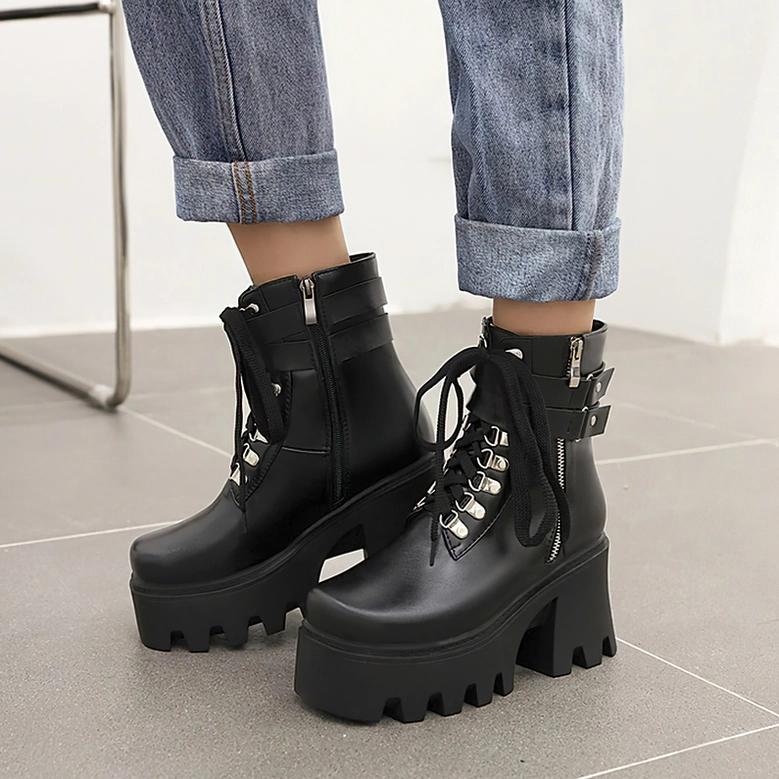 Black gothic platform combat boots styled with rolled denim, floor-level angle showing detailed lace-up system and chunky TPU sole