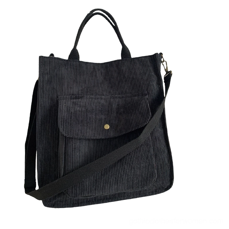 Black corduroy gothic tote bag with snap front pocket, flat lay view showcasing minimalist dark aesthetic and adjustable shoulder strap