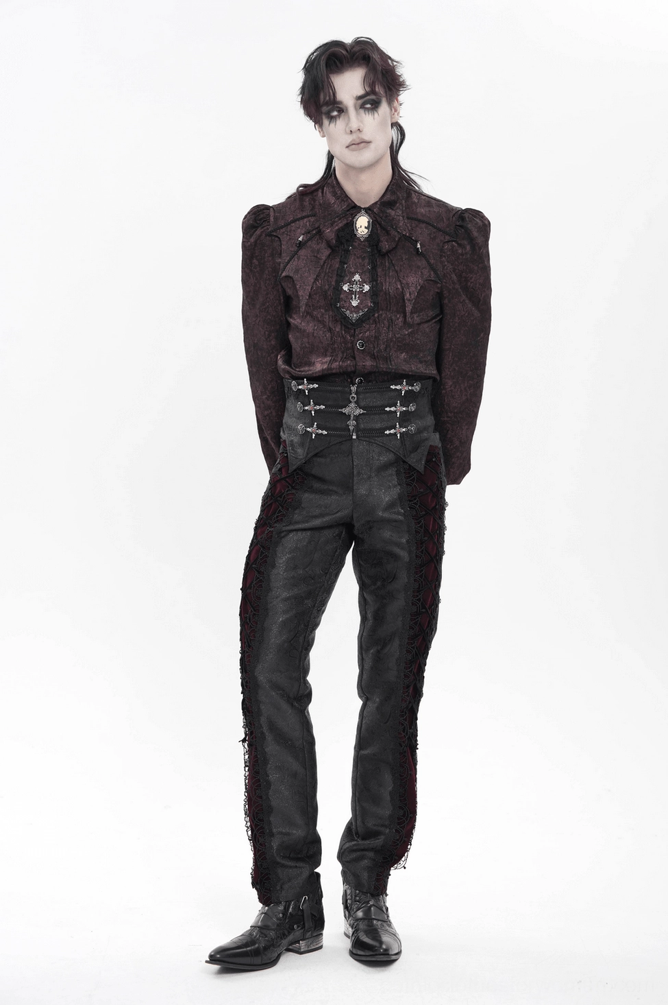 Model wearing black gothic cross corset belt layered over dark fashion outfit, alternative style presentation