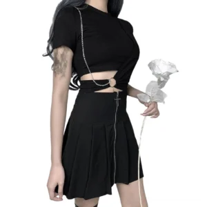 Gothic black crop top styled with pleated skirt, side angle view demonstrating chain embellishment and cutout waist detail