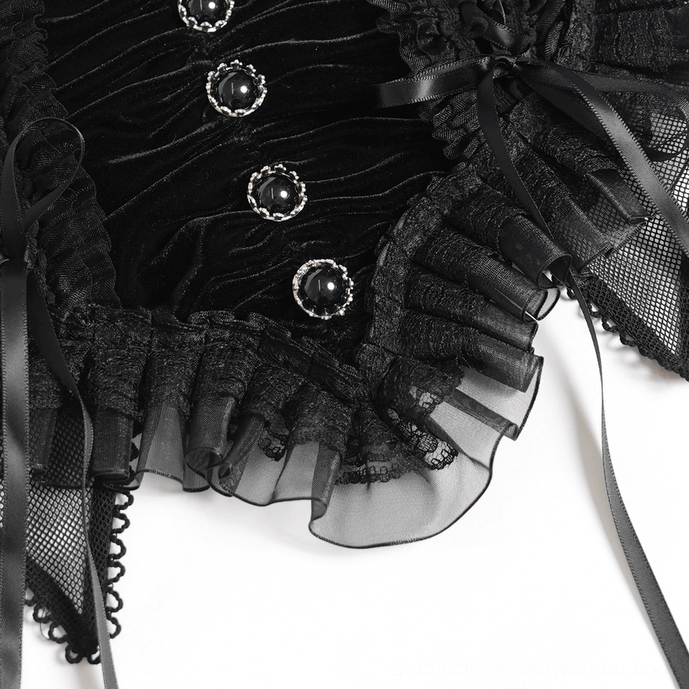 Close-up macro shot of black gothic crop top front featuring velvet texture, ribbon lace-up detail, and metal button embellishments