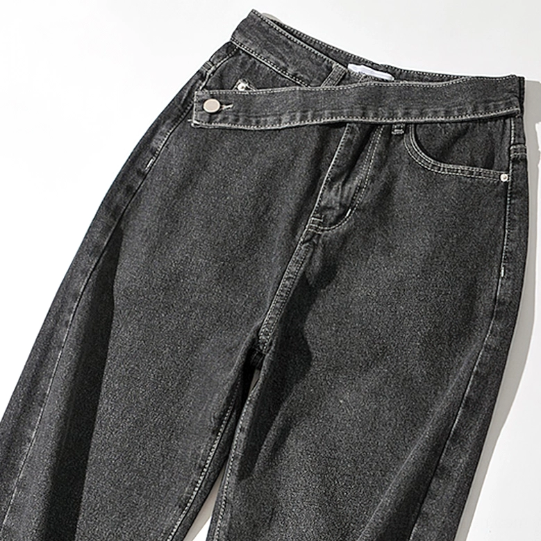 Black washed gothic denim jeans close-up front view showcasing heavy dark fabric and asymmetric waistband