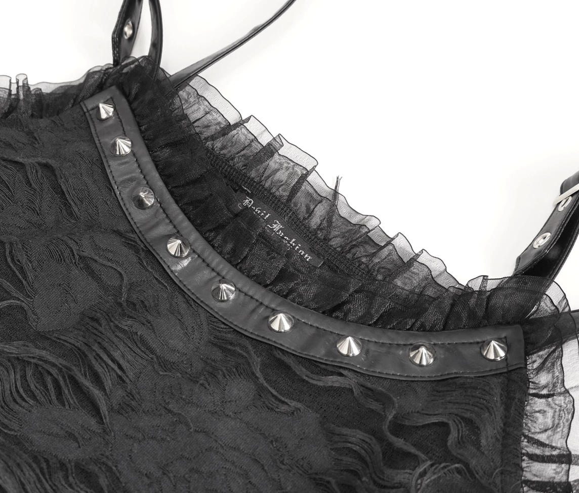Close-up detail of black ripped gothic dress showing studded collar trim, tulle lace overlay, and gothic hardware