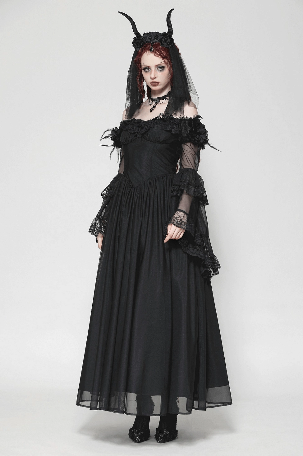 Black gothic maxi dress detail showing lace composition, feather shoulder accent, and construction of off-shoulder design