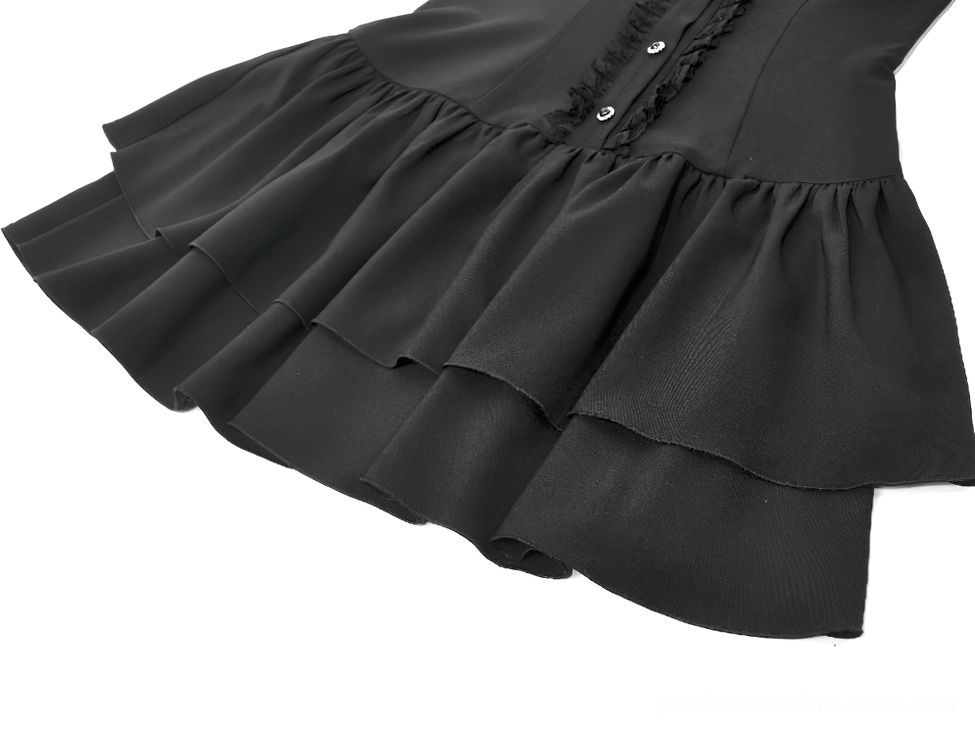 Close-up side view of black gothic dress hem showing layered ruffle construction, front button placket detail, and precision tailoring on white background