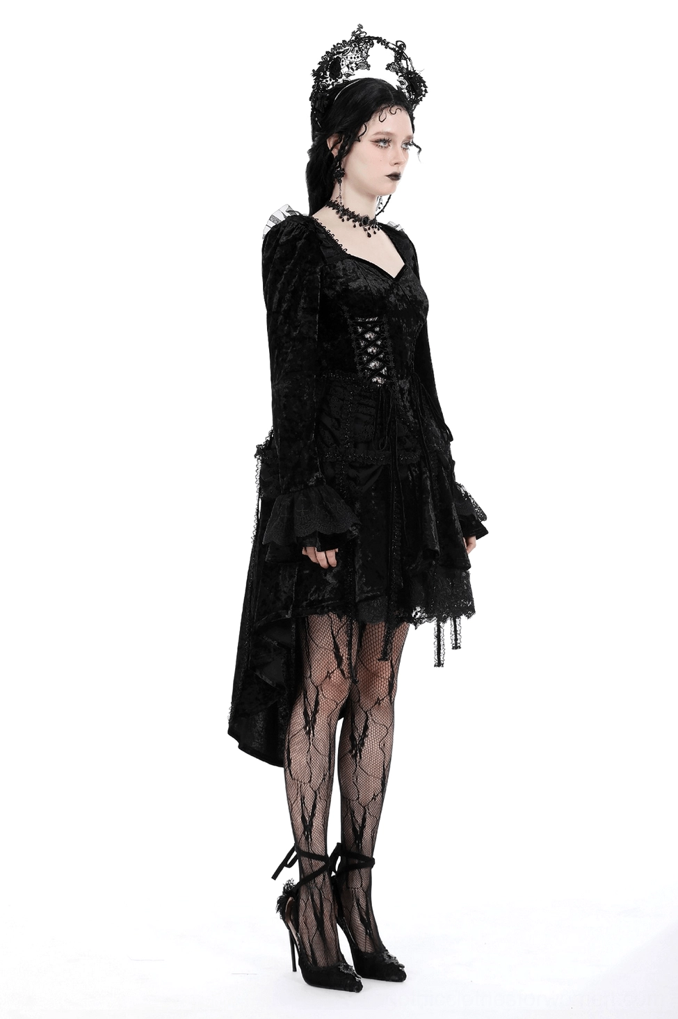 Black velvet gothic dress styled with fishnet stockings and heeled pumps, complete alternative goth aesthetic