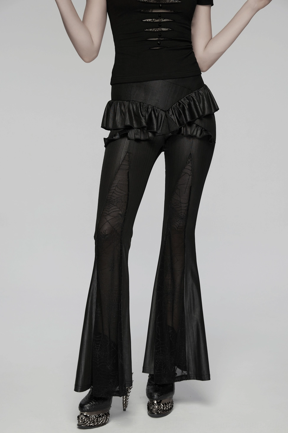 Black gothic flared pants full-body view displaying sheer spider web mesh panels, cross ruffle waist, and contemporary alternative fashion silhouette