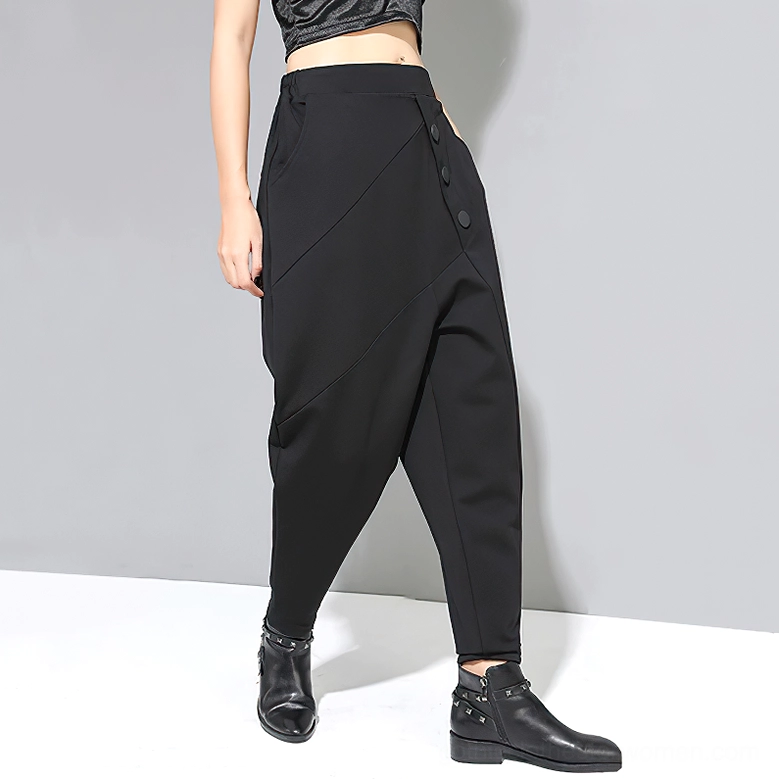 Black gothic harem pants three-quarter side view showing asymmetrical button placement and silhouette