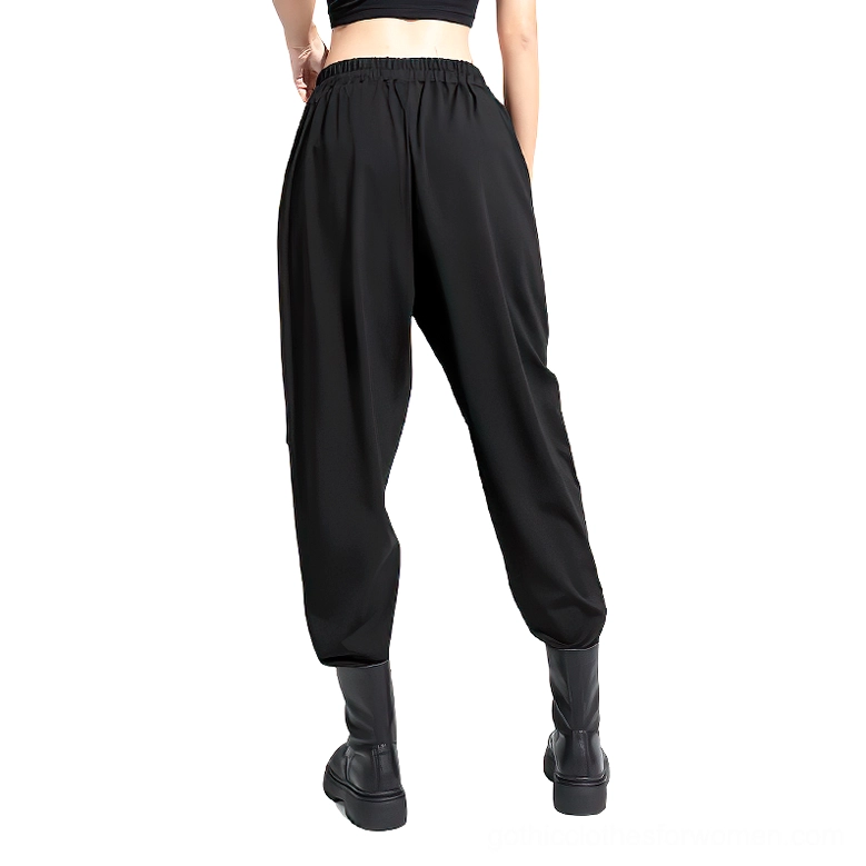 Rear perspective of black gothic high-waist trousers showing elastic waistband and tapered ankle cuffs with side ribbon detailing