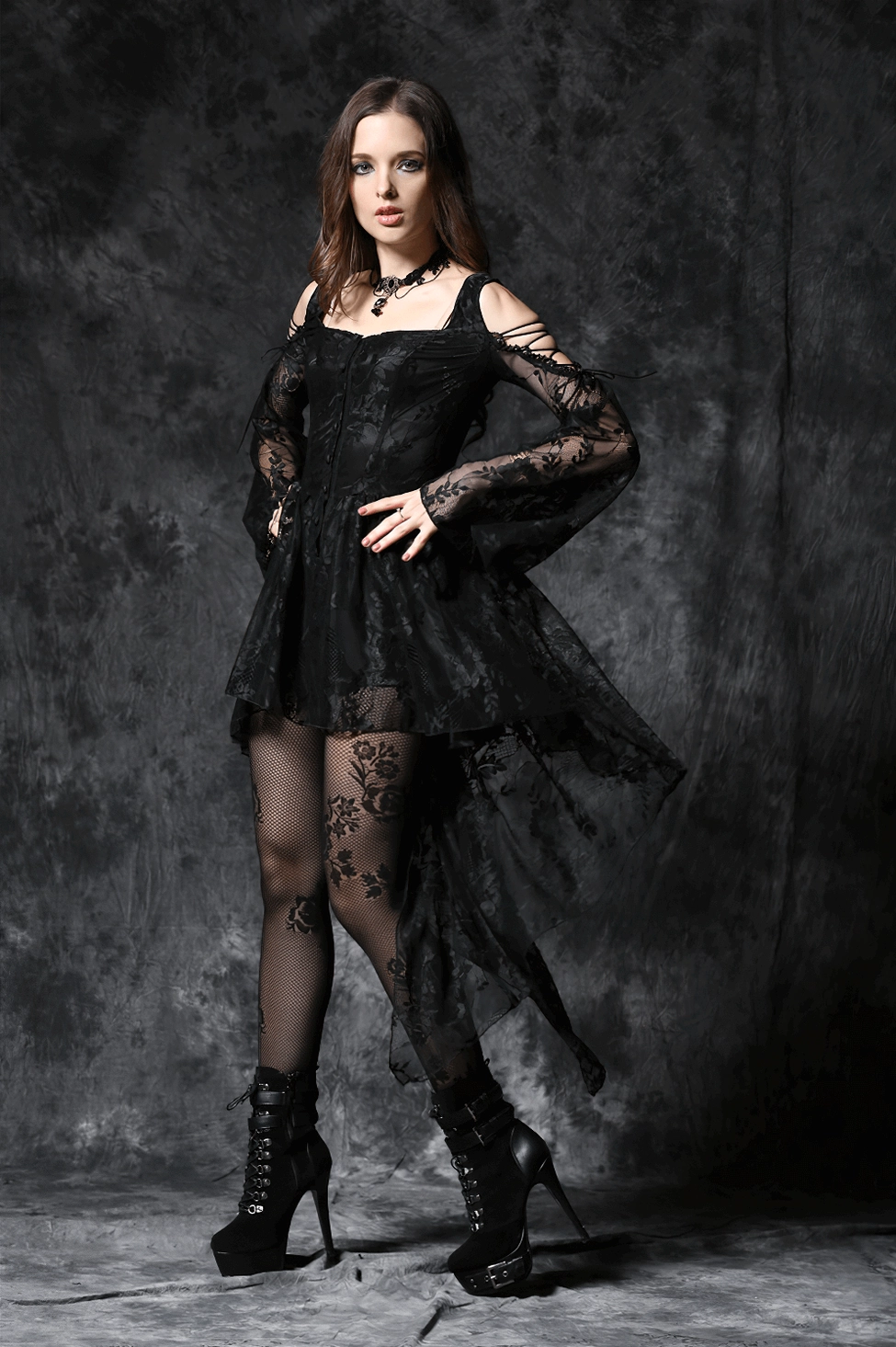 Model in black gothic high-low lace dress with combat boots, hands on hips pose