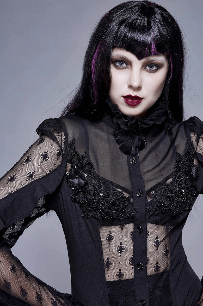 Female model wearing black gothic lace blouse with sheer lace panels, beaded floral trim, and high ruffled neck detail