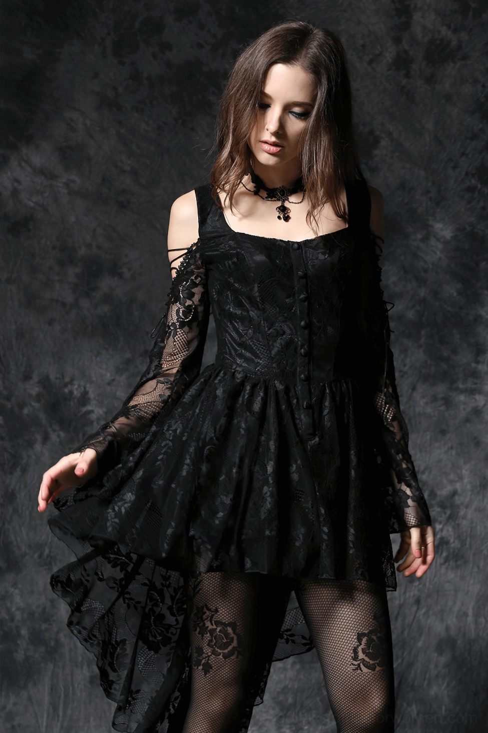 Model wearing black gothic lace dress with choker necklace and rose print fishnets on dark textured background