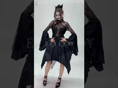 Model wearing black gothic lace dress with gemstone brooch collar and dramatic bell sleeves against dark background