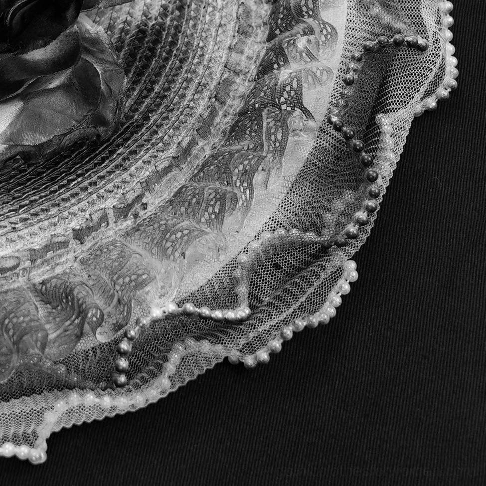 Black gothic lace fascinator hat with delicate floral accents and luxurious feather trim detail shot
