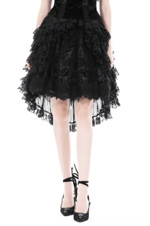 Black lace high-low gothic skirt with tiered ruffles worn by female model, front full-body view showing asymmetrical hemline and layered mesh panels