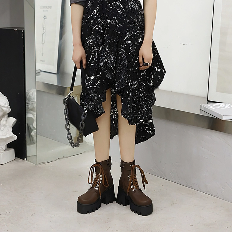 Black gothic platform combat boots with visible lace-up closure and side zipper, detailed three-quarter view of boot construction