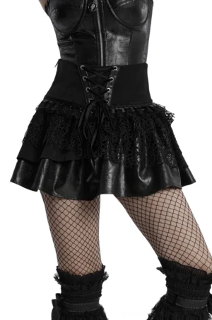 Black gothic lace-up mini skirt with layered mesh and faux leather detailing worn by model, front view showing metal eyelet lacing and ruffled hem