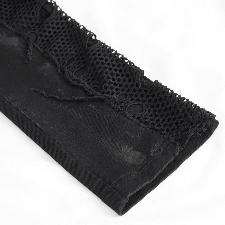 Close-up detail of fishnet panel and frayed fabric edge on black gothic punk trousers