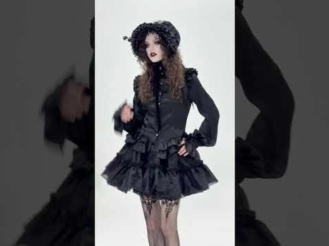 Gothic female model wearing black ruffled tulle mini skirt with fur hat and coordinated dark outfit, full body front view
