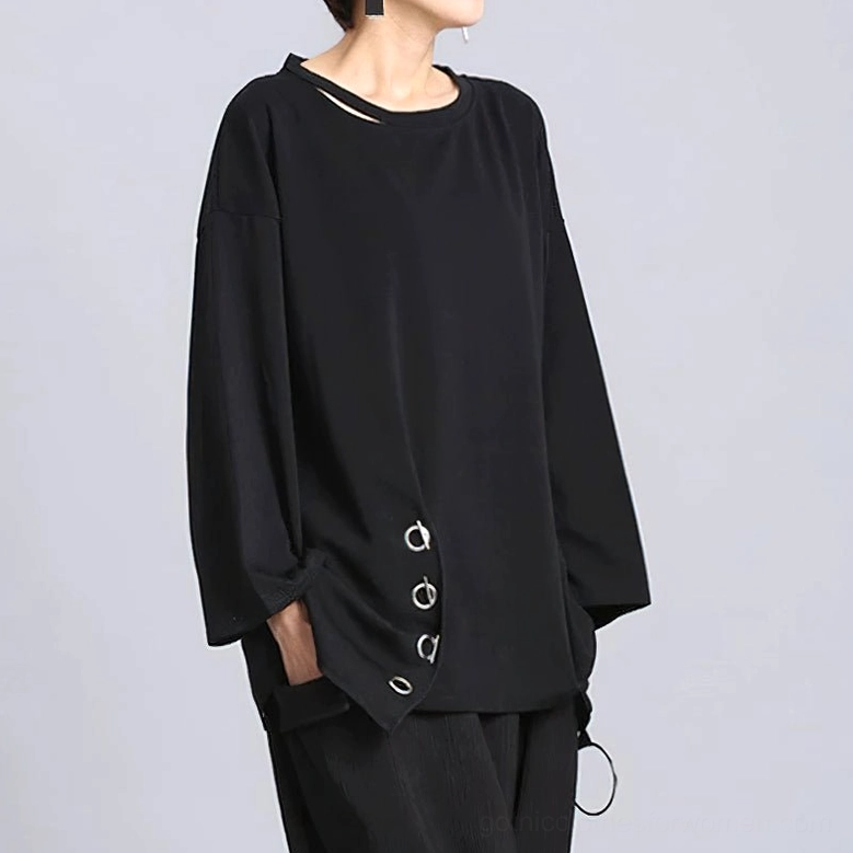 Black loose long sleeve gothic women's top worn by model, three-quarter side view displaying metal eyelet side decoration and wide sleeves
