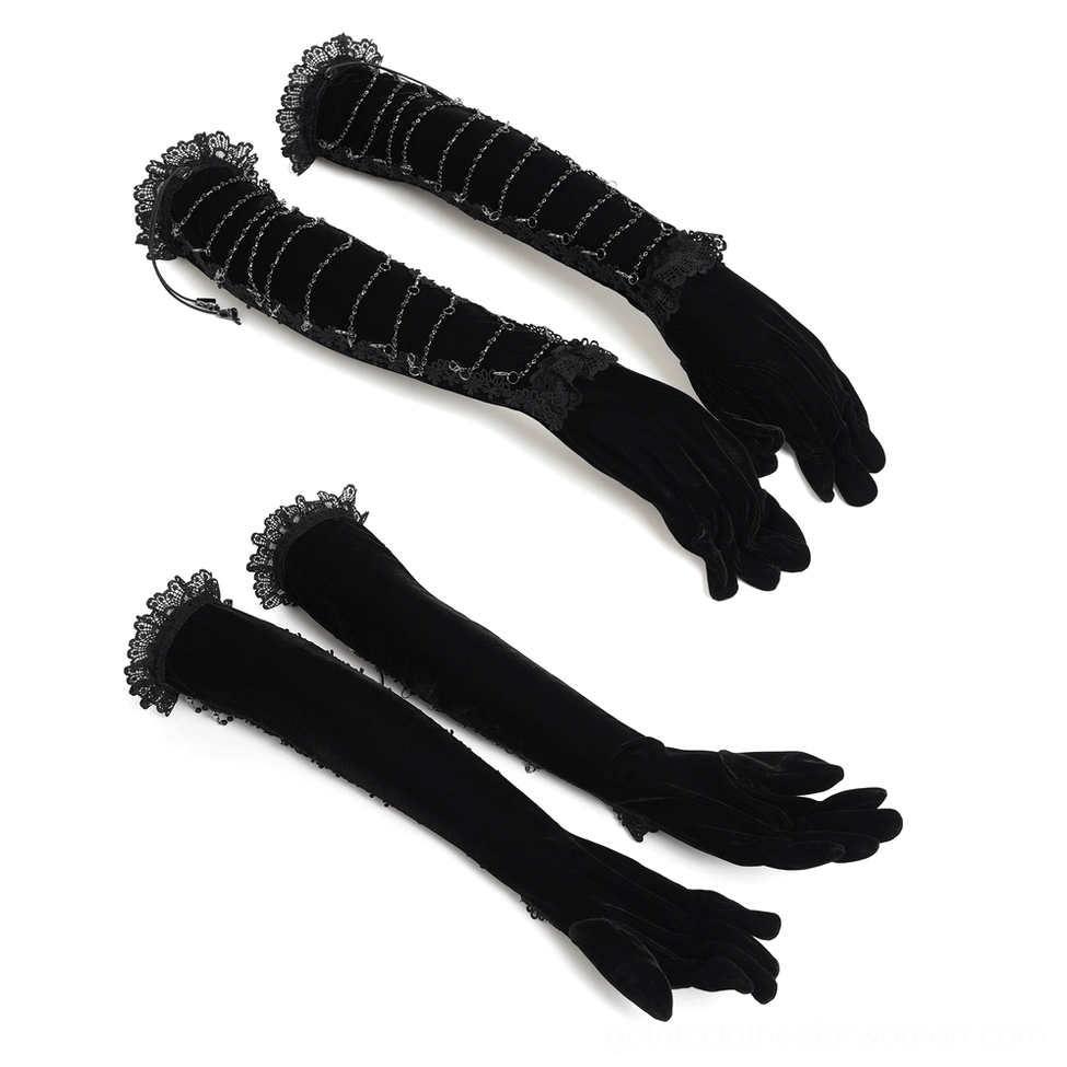 Flat lay display of black velvet opera gloves showing twisted metal chains, ruffled lace cuffs, and intricate hardware detailing on white background