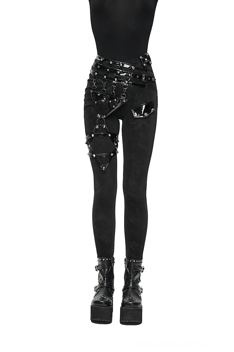 Women's black gothic pentagram harness pants front three-quarter view showing studded waistband and leg straps
