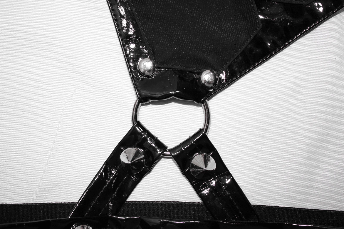Full-length side view of black gothic pentagram harness pants with all straps and hardware visible