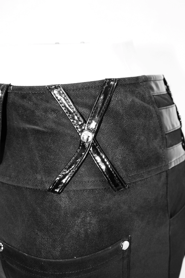 Side close-up of black gothic pentagram pants showing crisscross patent leather straps and layered waist trim