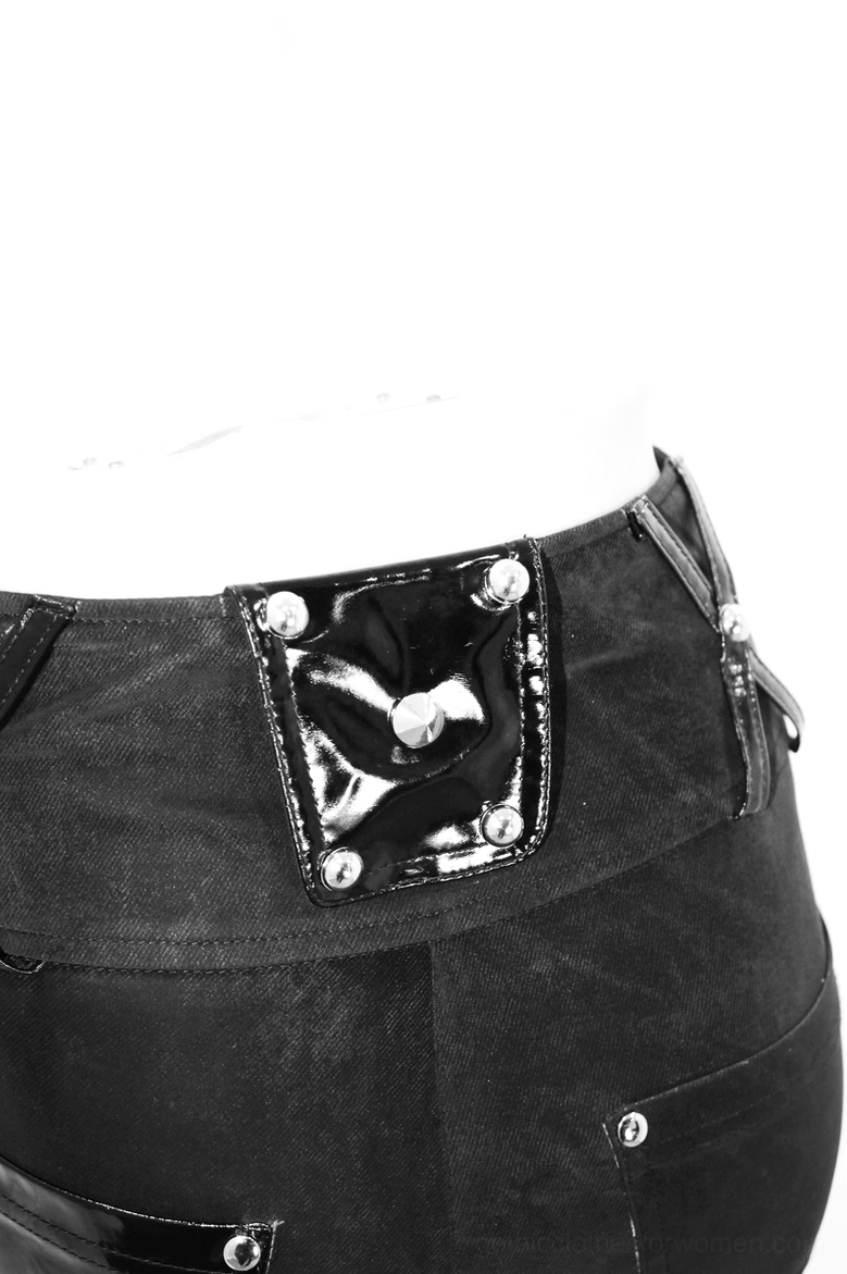 Close-up detail of black gothic pants waist showing patent leather pocket flap and metal rivets