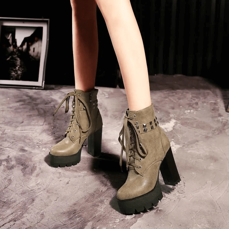 Black leather gothic platform combat boots showcasing studded strap and industrial details