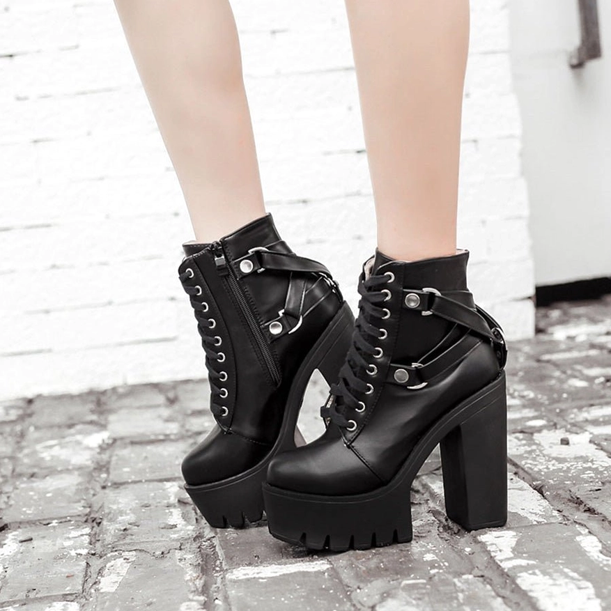 Model wearing black gothic platform boots outdoor front view - lace-up front closure and high platform stance on cobblestone street