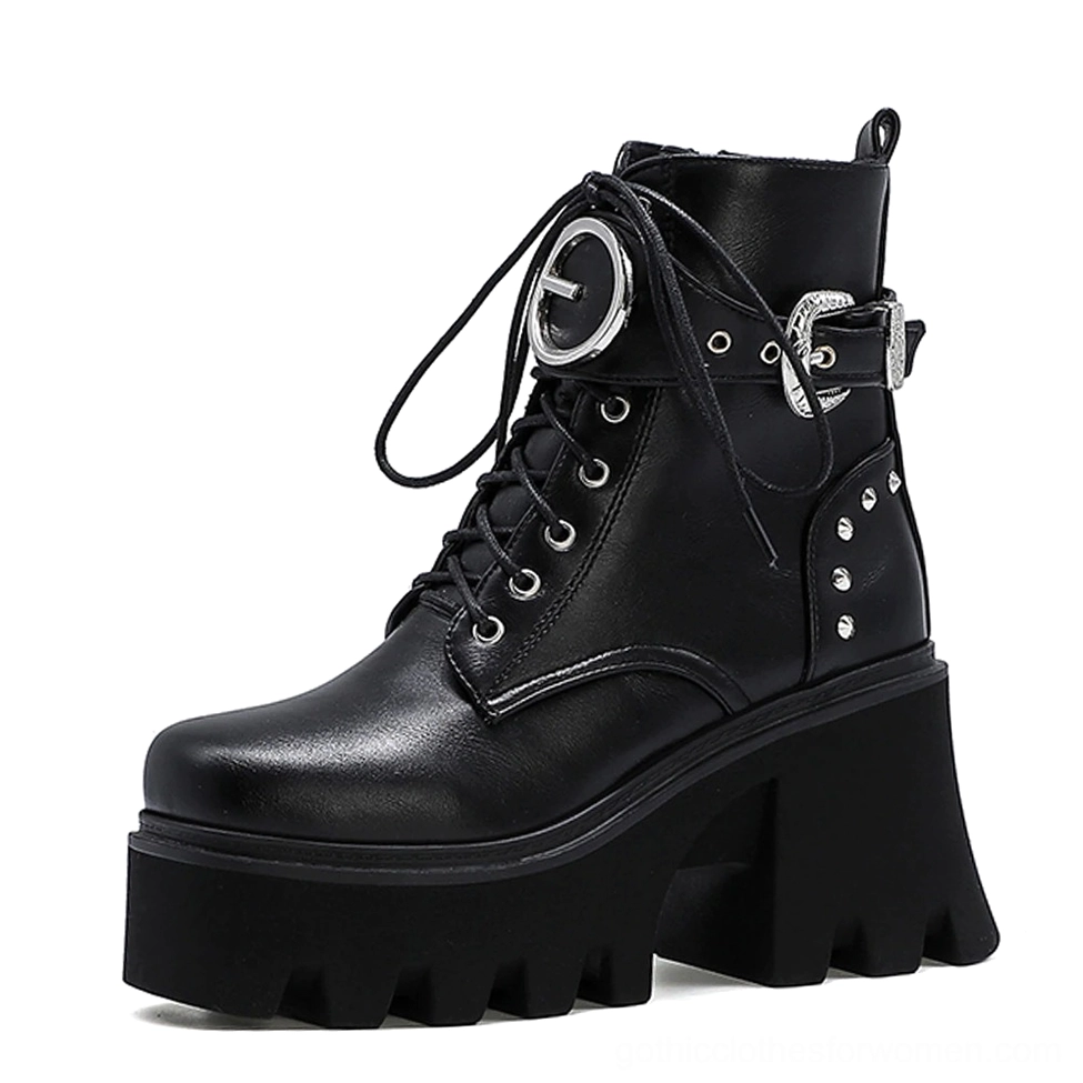 Black gothic platform combat boots with metal buckles and studded details, left three-quarter view showing architectural square heel and PU leather upper