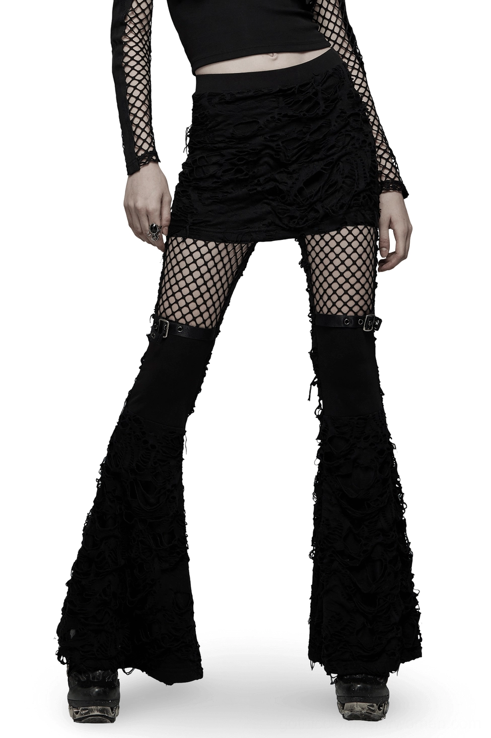 Black gothic ripped flare pants with mesh thigh panels and attached mini skirt, front 3/4 view on model