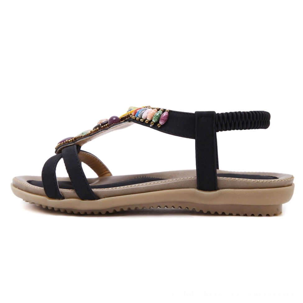 Black beaded gothic sandal with intricate gemstone decorations and elastic back strap, side profile view