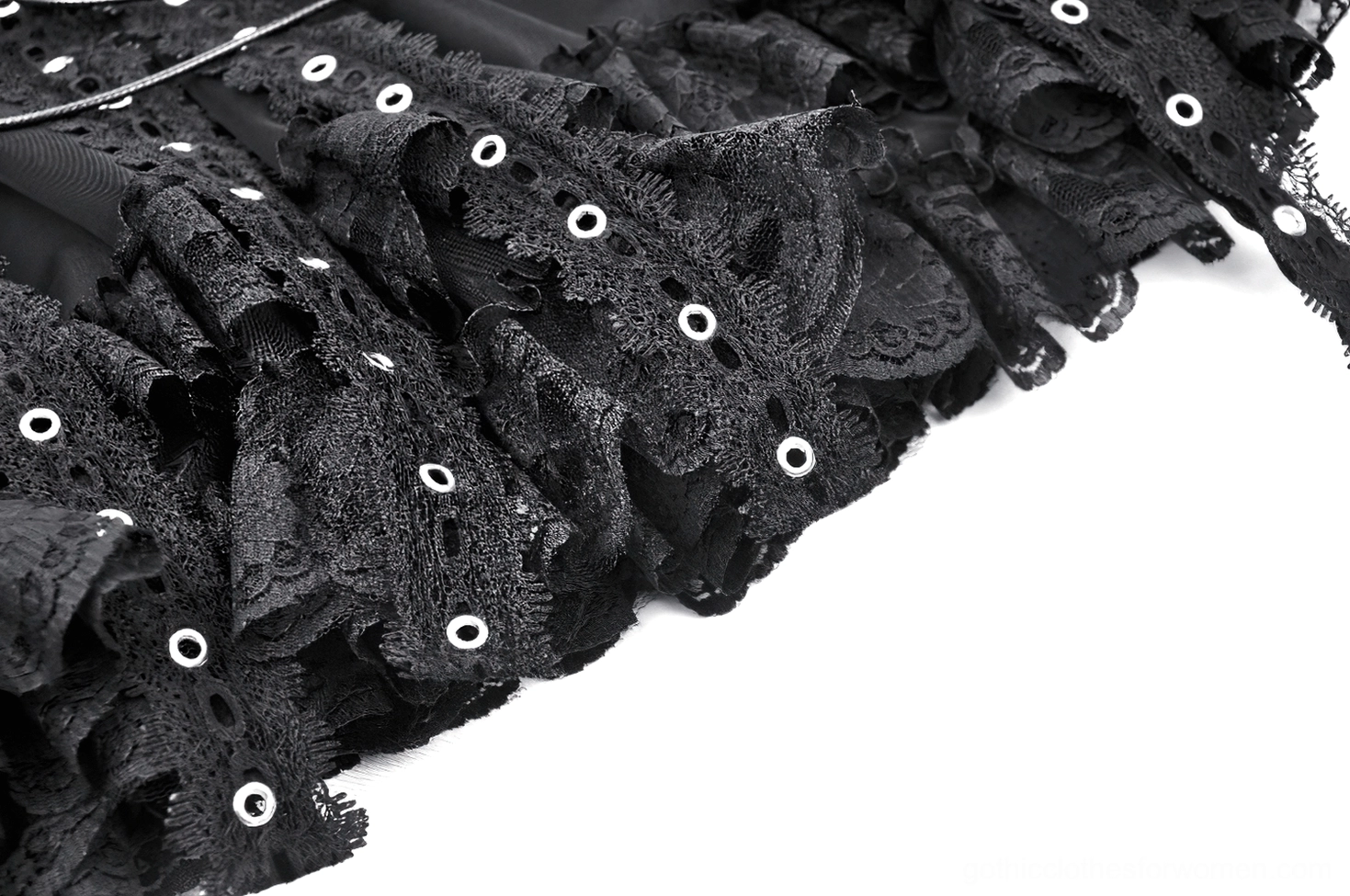 Detailed close-up of black gothic skirt ruffle hem showing lace trim, metal eyelets, dangling drawstrings, and sheer tulle layering