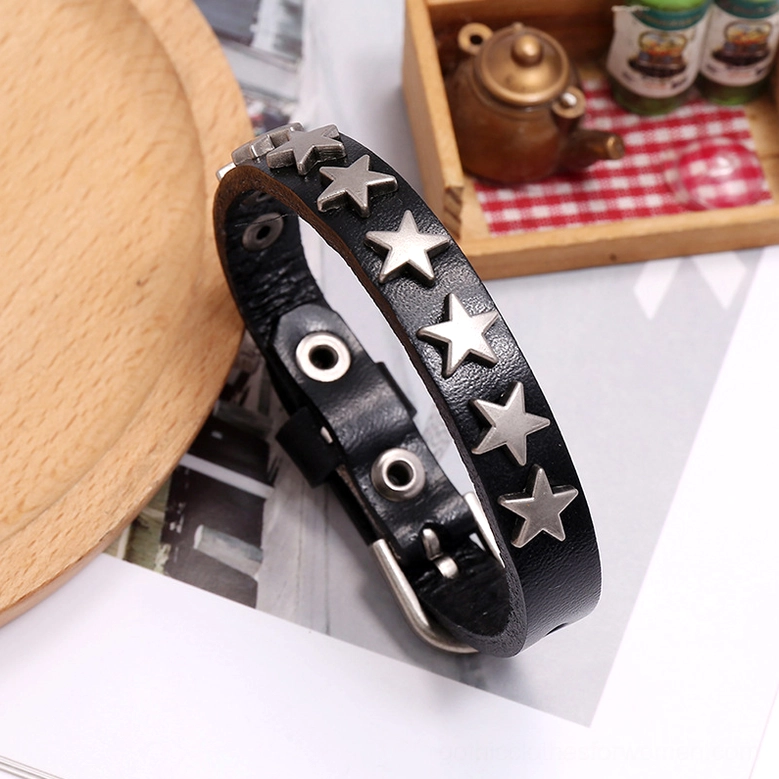 Black gothic star leather bracelet close-up detail shot on table surface showcasing silver star rivet craftsmanship