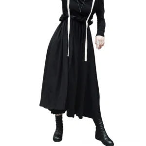 Black gothic suspender skirt with contrasting beige straps, side view showing A-line silhouette and raw hem on female model