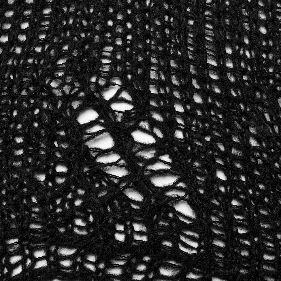 Close-up detail of black distressed knit fabric showing irregular ripped mesh weave pattern and distressing craftsmanship