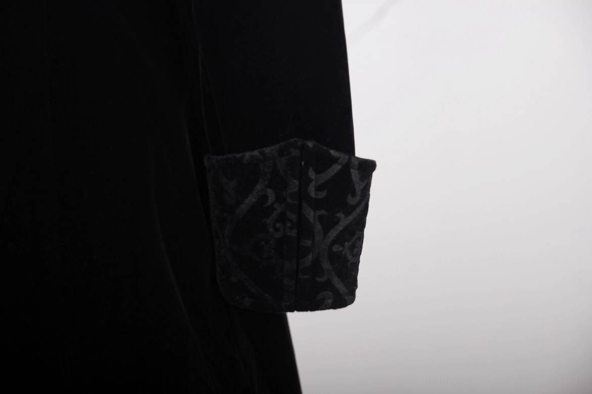 Close-up detail of black velvet gothic tailcoat cuff featuring vintage embroidered pattern on luxurious fabric