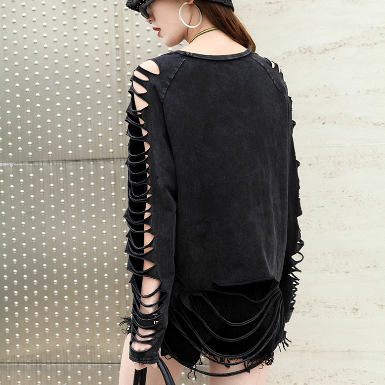 Full back view of black gothic long sleeve tee with cutout side sleeves and tassel back hem against industrial metal background