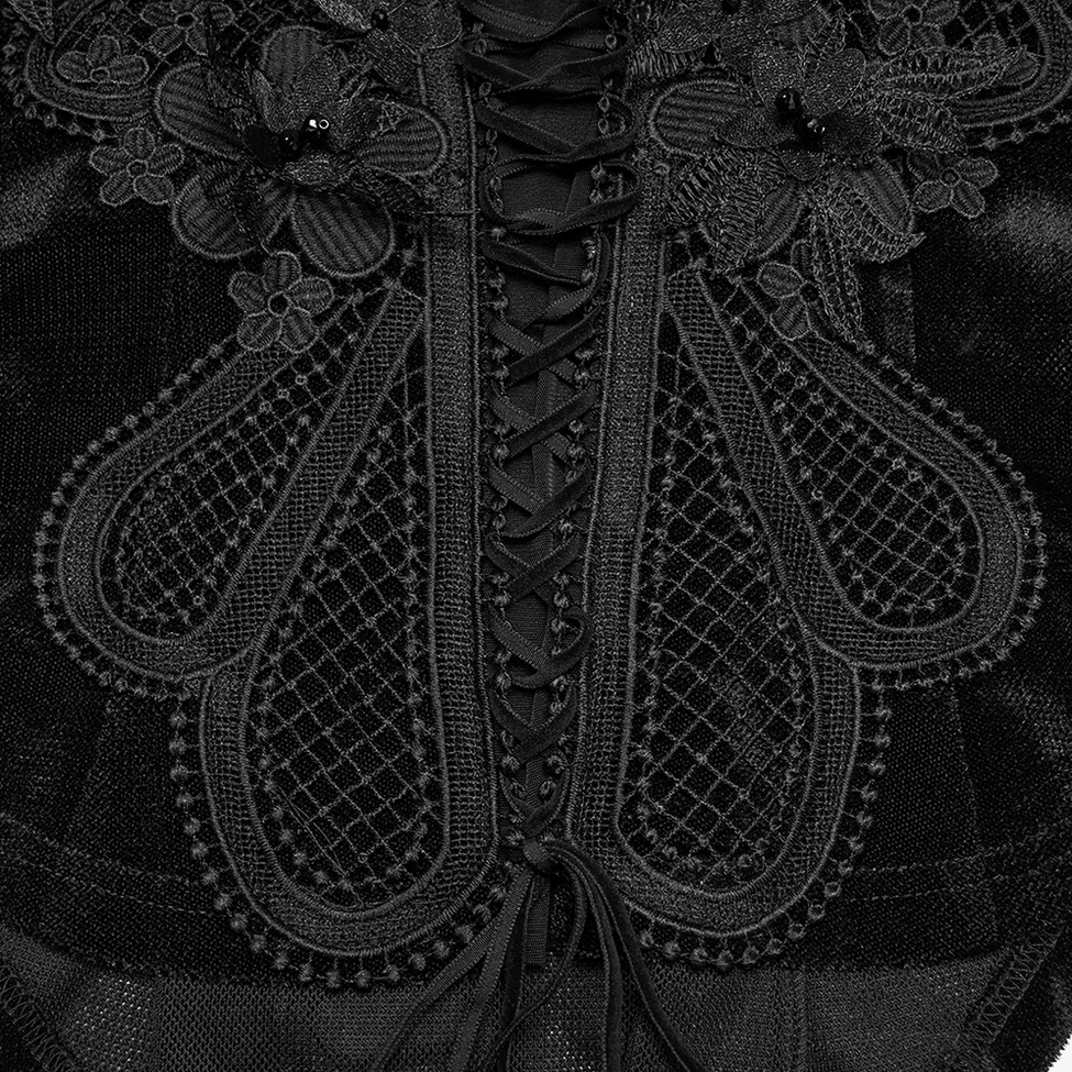 Close-up of chest paisley and floral embroidery with decorative trim on black gothic mesh top