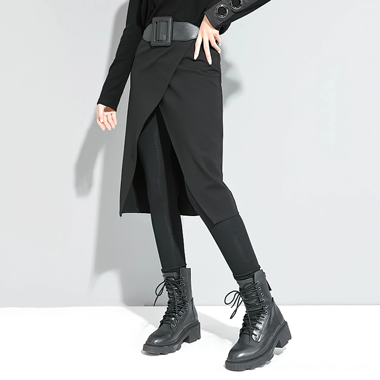 Black gothic split skirt pants worn by model with hand on hip - three-quarter front view of clean tailored silhouette