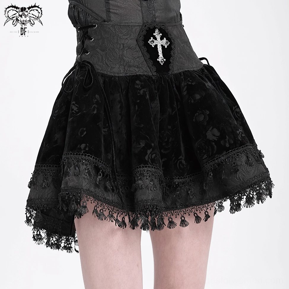 Black velvet gothic mini skirt product shot showing full front silhouette with cross embroidery, lace-up waist, and ruffled tassel hem