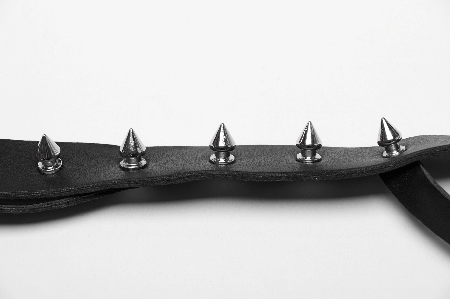 Black leather body harness with metal studs and chain accents, close-up structural view