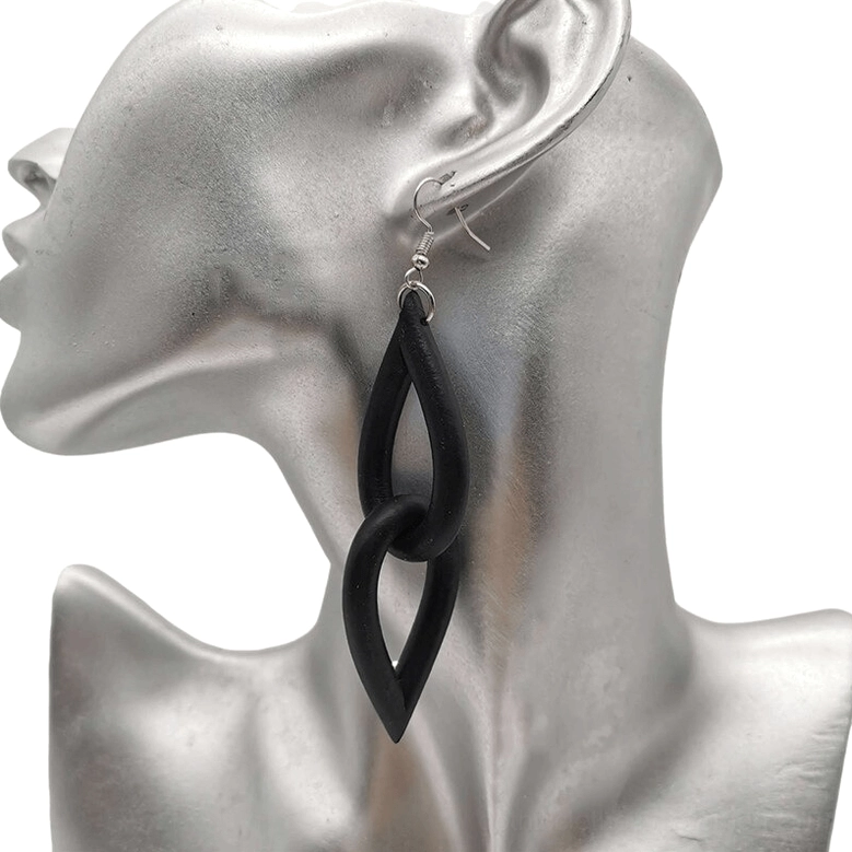 Black interlocking teardrop rubber earrings displayed on silver mannequin bust, showcasing neo-gothic handmade drop earring design with matte finish and silver ear hooks from side angle
