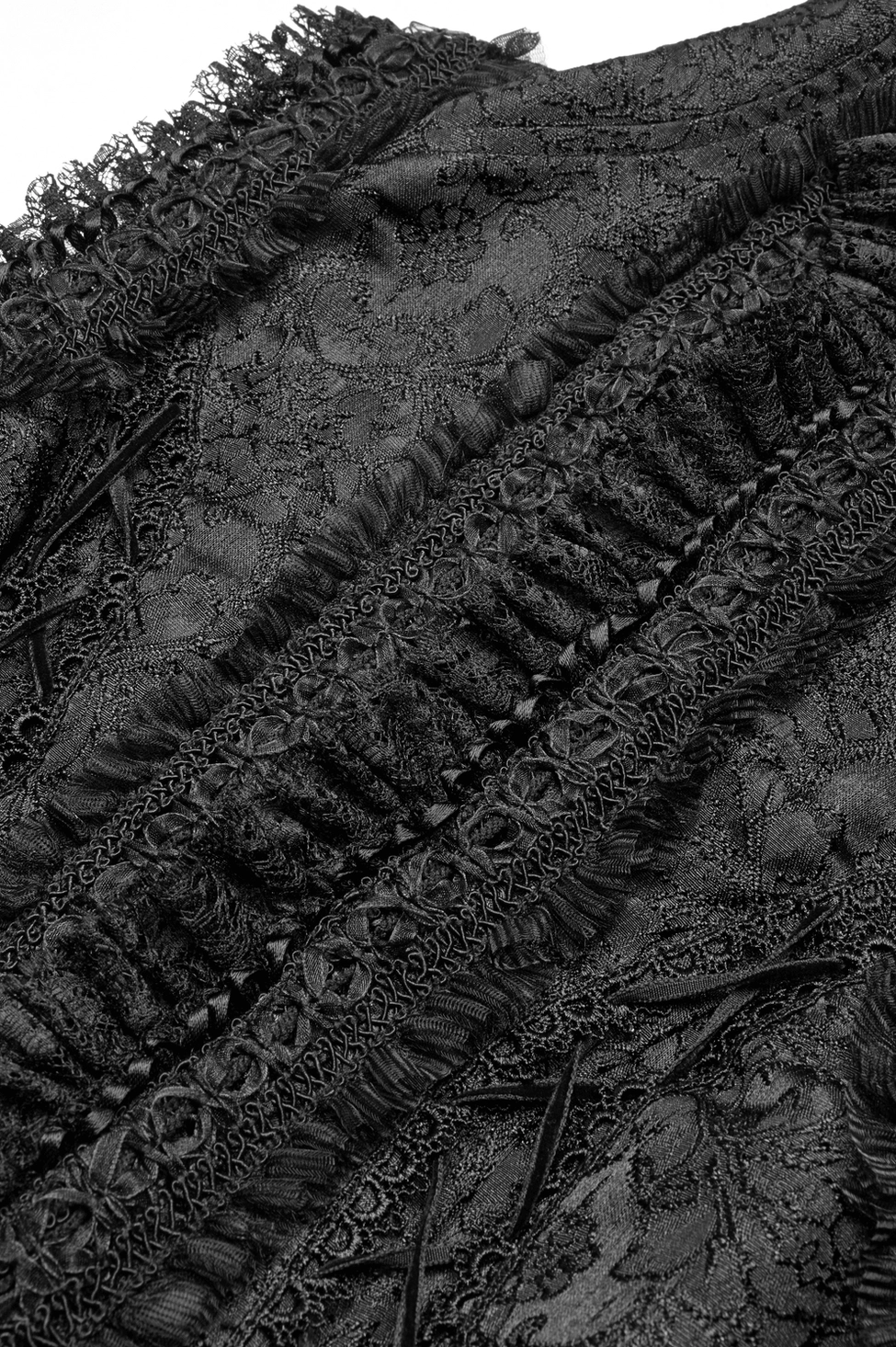 Close-up side trim detail of gothic waistcoat showing frilled lace edge and ribbed jacquard fabric weave