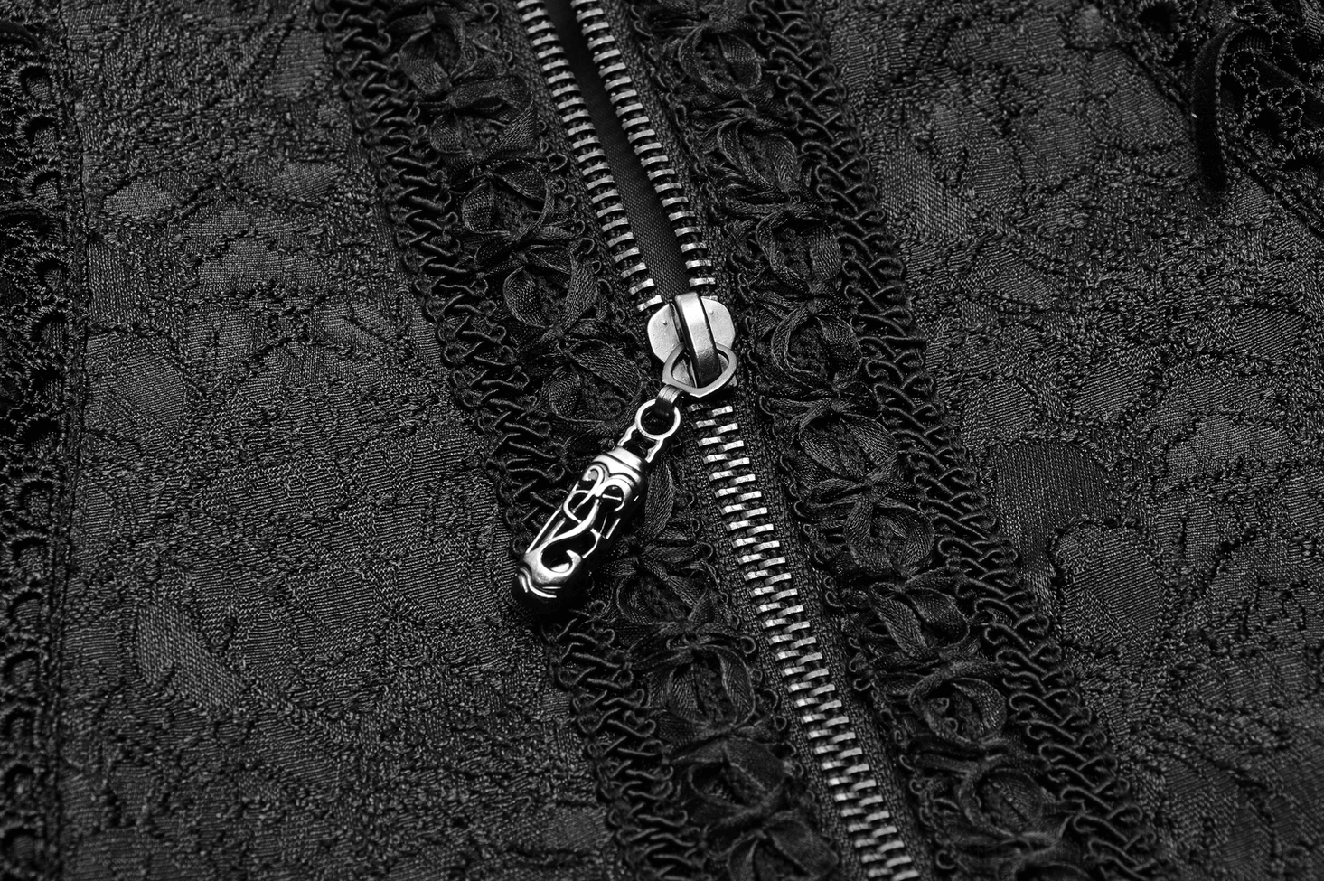 Black gothic waistcoat detail shot showcasing intricate jacquard weave pattern and lace finishing