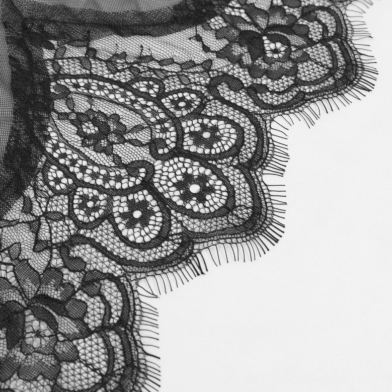 Black floral lace fabric close-up with scalloped eyelash trim detail