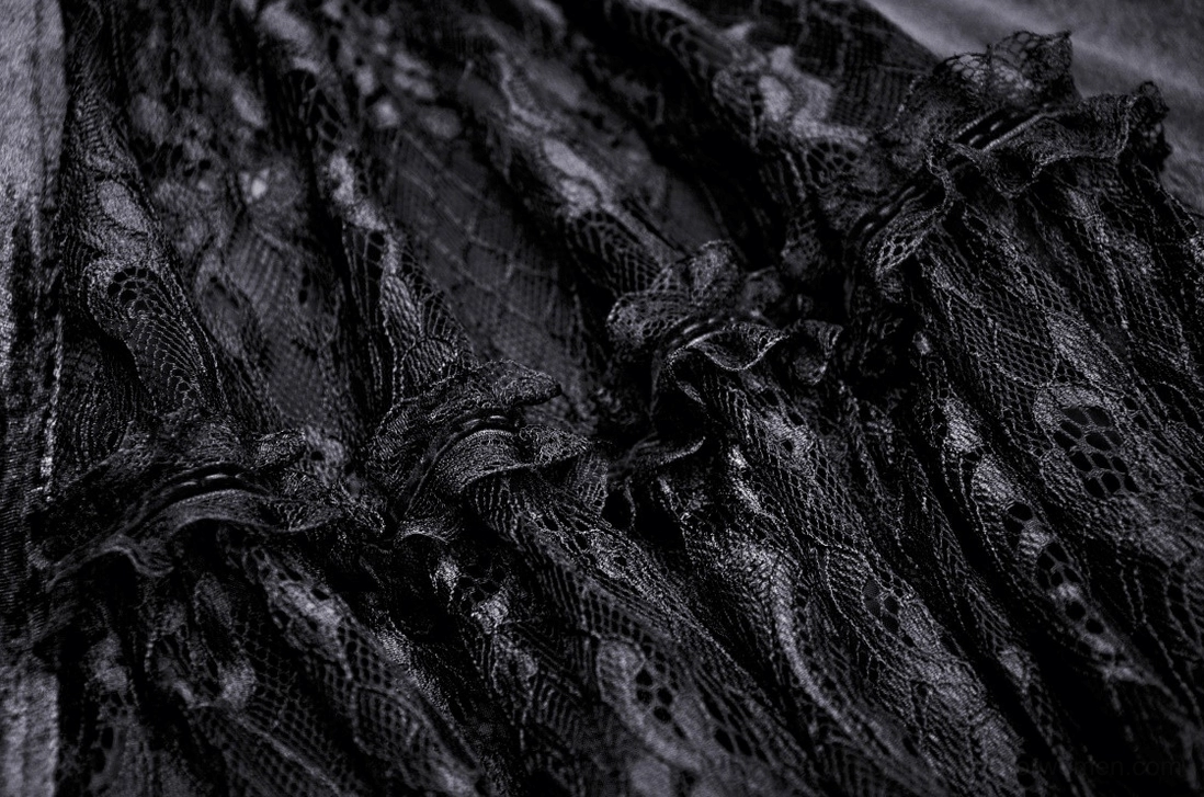 Macro close-up of black lace fabric showing intricate floral lace pattern with ruffled trim on gothic gown