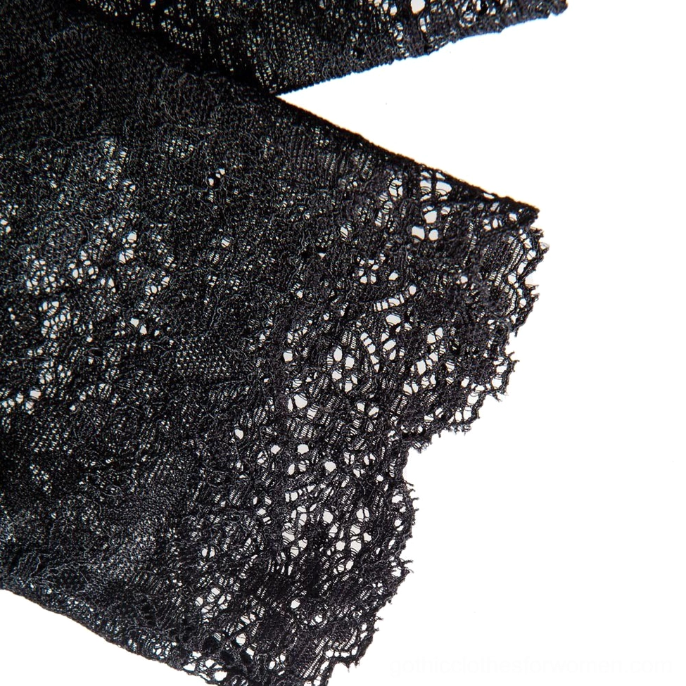 Close-up of black lace fingerless gloves showing intricate floral lace pattern and scalloped hem finishing